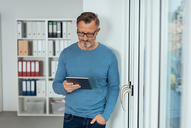 Mann schaut auf eine Checkliste auf dem Tabletcomputer Mann schaut auf eine Checkliste auf dem Tabletcomputer