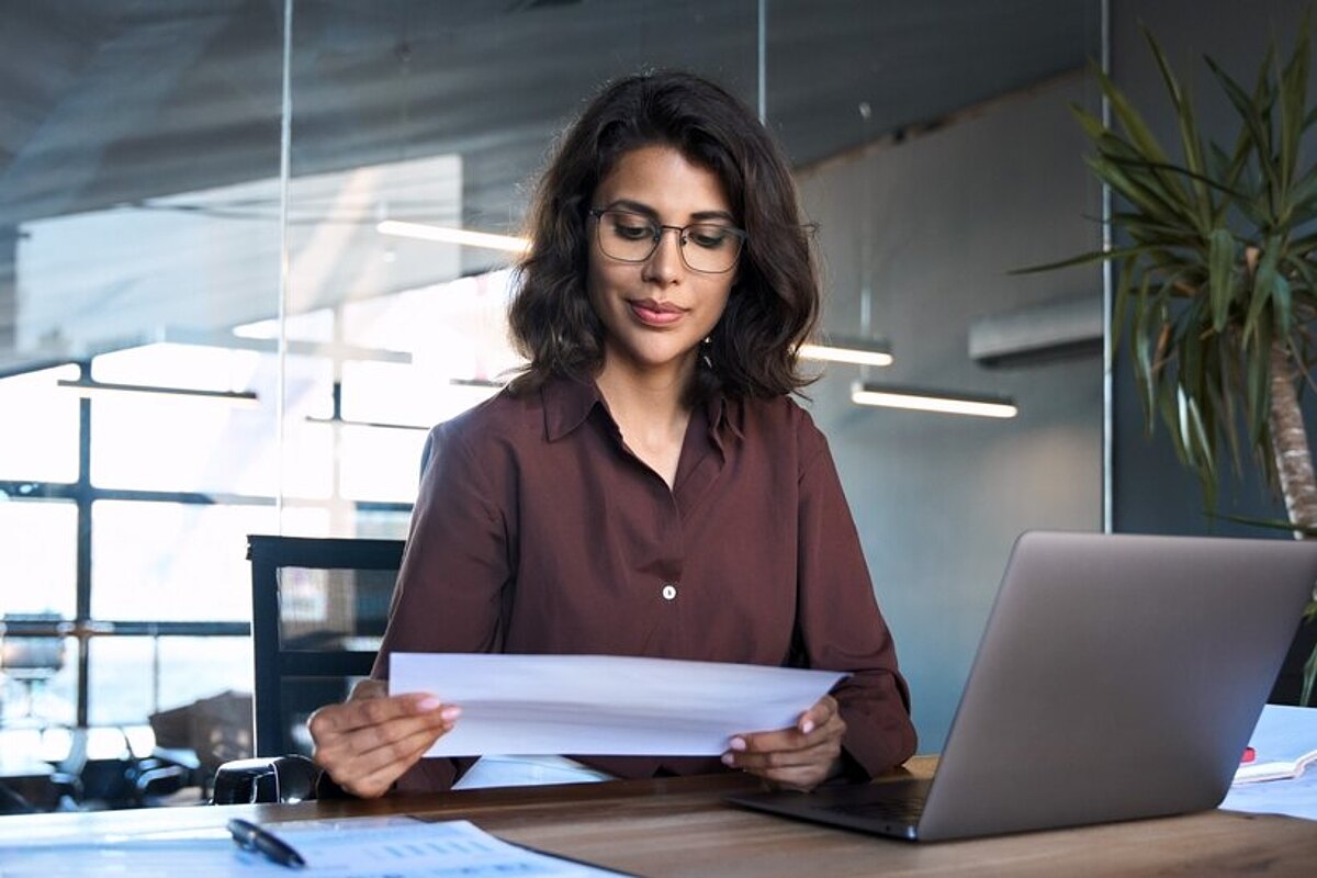 Eine Frau bereitet Unterlagen für die Teilnahme an einer öffentliche Ausschreibung vor Eine Frau bereitet Unterlagen für die Teilnahme an einer öffentliche Ausschreibung vor