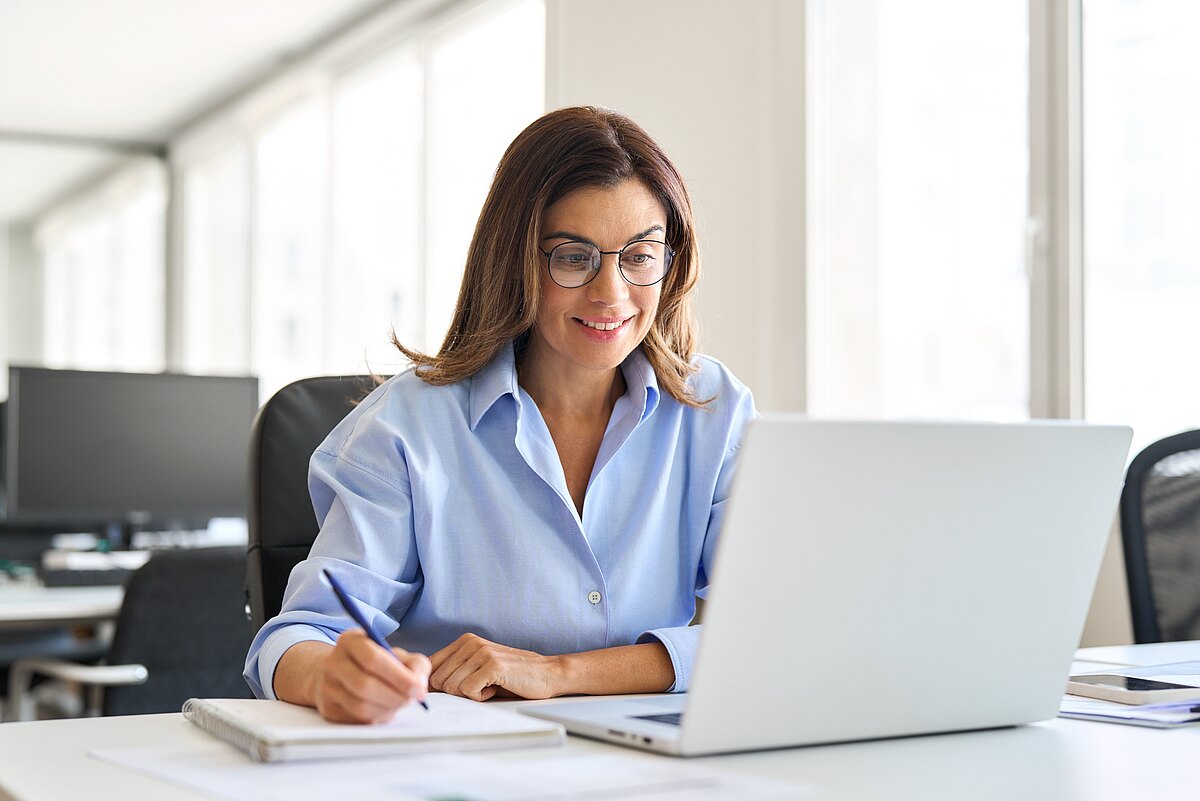 Eine Frau sitzt am Laptop und arbeitet sich in das Thema öffentliche Ausschreibungen ein